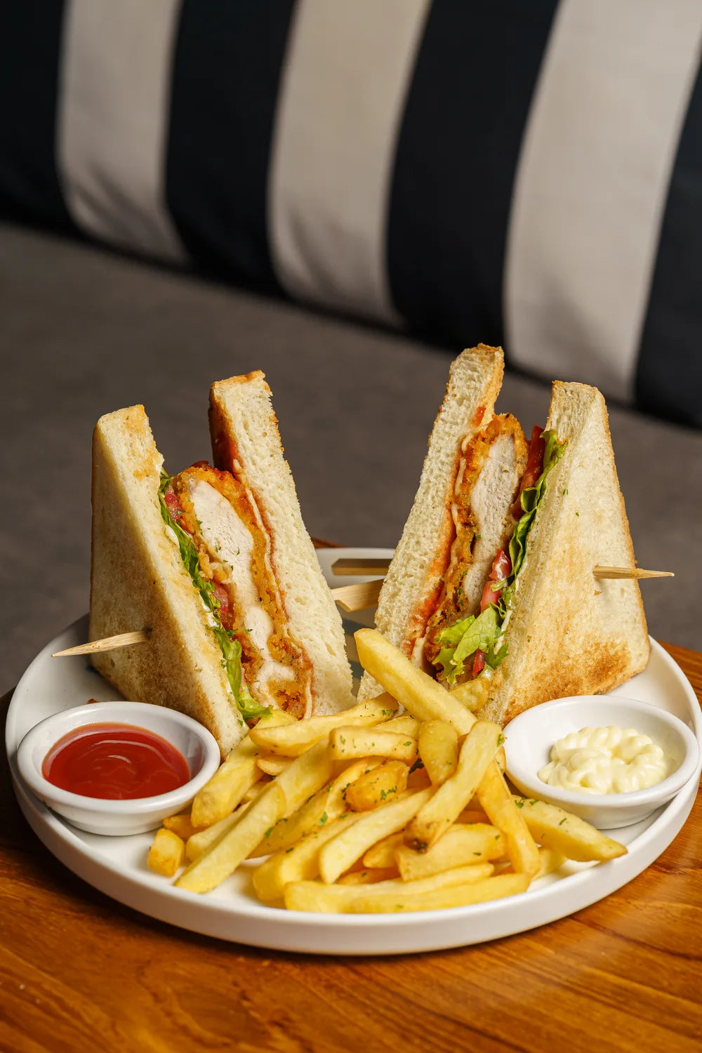 Toasted sandwich halves served with fries and dipping sauces.